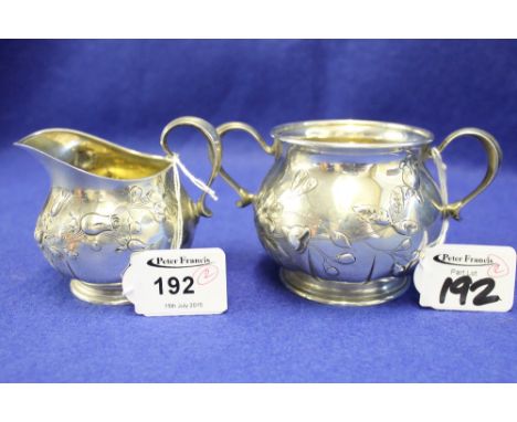 Two piece sterling silver Tiffany & Co. cream jug and sucrier overall decorated with a repousse floral sprays, engraved 1887-