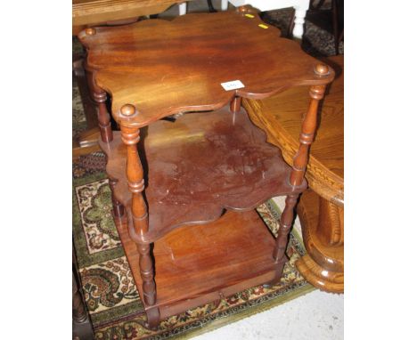 Mahogany three tier single drawer whatnot with shaped apron and ceramic casters.