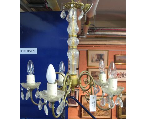 Gilt metal, five branch, scroll design ceiling light with prismatic drops and fluted glass stem.