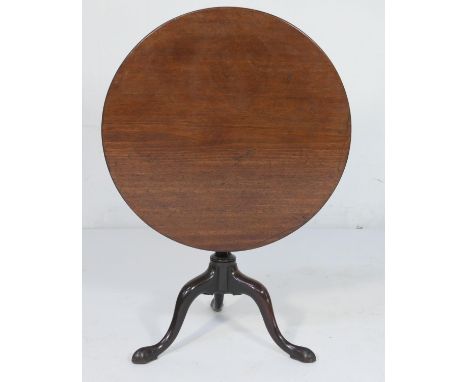 Mahogany tilt top tripod table, 19th Century, circular one piece top tilting over a wrythen moulded baluster column and three