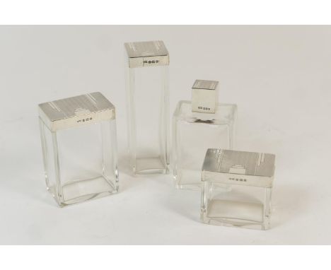 Four Art Deco silver topped bottles, by Deakin &amp; Francis, Birmingham 1934, each of plain form, the covers with engine tur