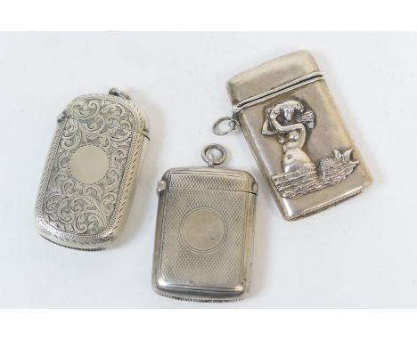 Three silver vesta cases, comprising one of cushion form with scroll engraved decoration and vacant cartouche, Birmingham 189