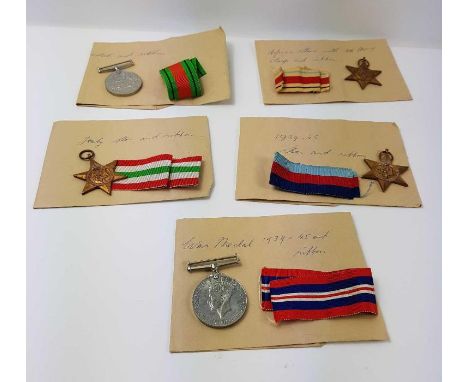 A group of WWII medals with ribbons - the Defence medal, the 1939-45 War medal, the 1939-45 Star, the Italy Star and the Afri