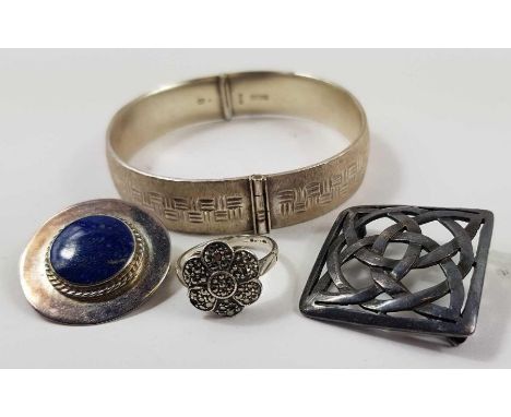 A silver hinged bangle with geometric bright cut decoration, hallmarked Sheffield 1977, a round silver brooch set with a lapi