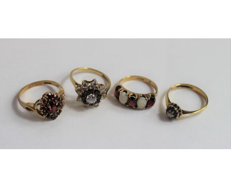 A 9ct gold garnet cluster ring, a 9ct gold garnet and opal five stone ring, a 9ct gold sapphire and diamond cluster ring and 