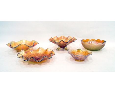 Five marigold Carnival glass bowls including one decorated with cherries on a tripod base, another decorated with grapes, etc