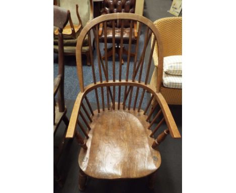 A Victorian elm double comb back Windsor armchair, the hoop arms over a solid seat, raised on splayed ring turned supports an