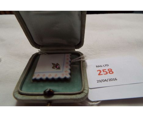 A French enamelled brooch in the form of a handkerchief corner with hand painted decoration and fleur-de-lis set with diamond