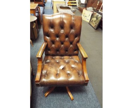 A 20thC leather button back desk chair with adjustable swivel base and raised on five out swept feet