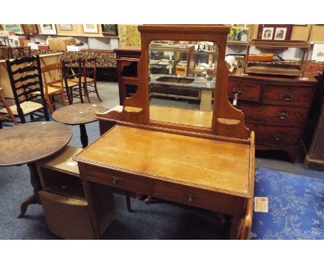 An Edwardian light oak dressing table with bevel mirror back over two short drawer and raised on tapering ring turned support
