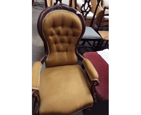 A Victorian mahogany spoon and button back nursing chair in gold upholstery in need of restoration