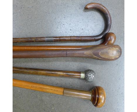 Four walking canes and a walking stick