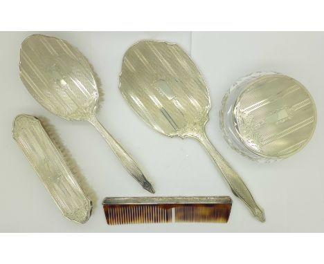 A silver topped glass jar, a silver backed mirror, two brushes and a comb