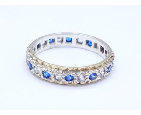 A 9ct gold and silver, blue and white stone eternity ring, Q