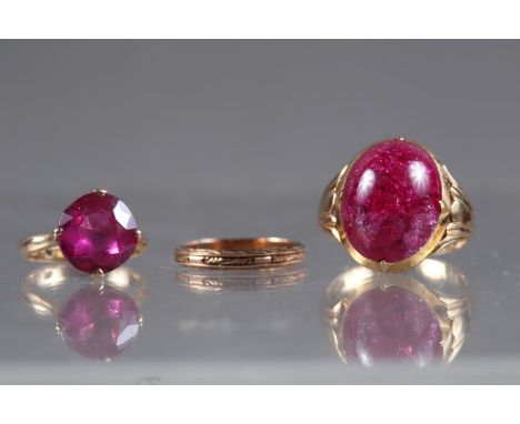 A yellow metal and pink cabochon dress ring, size O, 6.7g, a yellow metal and ruby coloured dress ring, size G, 3.3g, and a y