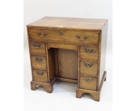 George III mahogany kneehole desk, the moulded caddy top above seven drawers and centre cupboard, raised on bracket feet, 66c