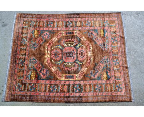 Bastan carpet with a medallion and stylised floral design on a fawn ground, in shades of rose, blue, cream and yellow, 261cms