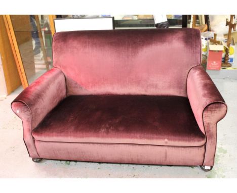 Early 20th Century purple velvet upholstered two seat sofa on bun front supports150cms wide x 83cms high x 80cms deep.Seat de