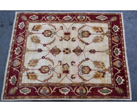 Afghan carpet of Ziegler design with an all-over palmette pattern on an ivory ground with red ground borders, 305cms x 239cms