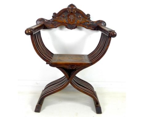 A 19th century walnut Savonarola chair, the back carved with crests, animals and armorials, squared and carved arms with ball