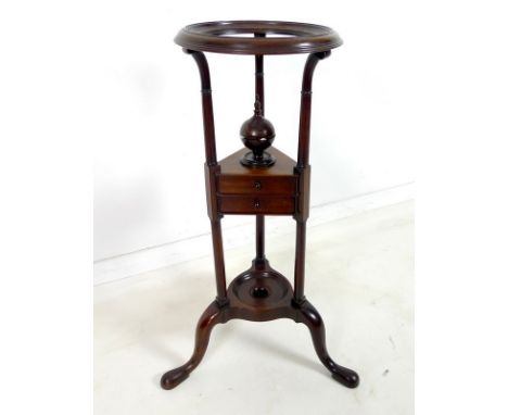 A Georgian mahogany wig stand, with circular moulded top above column supports and triangular medial shelf fitted with two dr