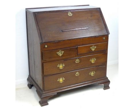 A George I oak bureau, with fall front fitted with moulded decoration and pierced brass escutcheon, interior fitted with a se