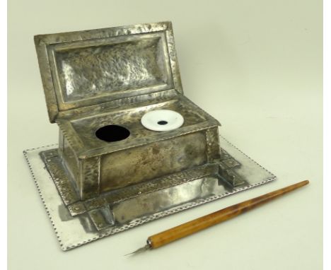 An Arts & Crafts white metal desk stand, hammered and riveted, with domed lid and punched edges, interior with two ink holes,