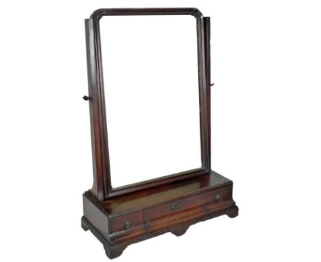A George III mahogany toilet mirror, the rectangular plate with moulded frame, supported over a scoop fronted base with three