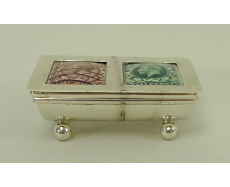 A silver double stamp casket, of lidded trough form on ball feet, with ceramic three half penny and half penny George V stamp