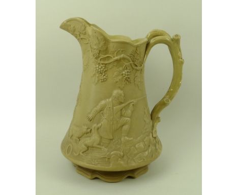 A Victorian stoneware pitcher jug, by Cobridge, cast in relief with a hunting, the handle formed as a tree branch, fruiting v