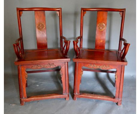 A Pair of Chinese Hardwood Armchairs, each with a shaped carved back above a panel seat raised upon square legs with stretche