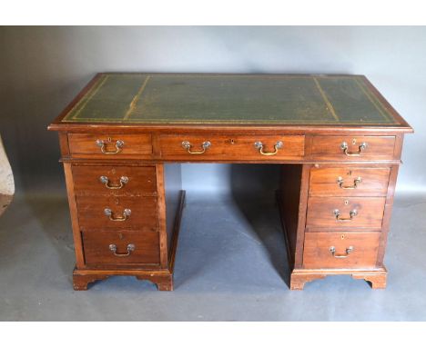 A Edwardian Mahogany Twin Pedestal Desk, the green tooled leather inset top on nine drawers with brass handles raised upon br