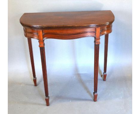 An Edwardian Mahogany Line inlaid Card Table with hinged reeded top above a shaped frieze, raised upon reeded square tapering