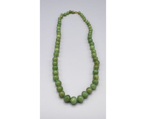 A Jade Bead Necklace with graduated beads and yellow metal clasp, 65cm long 