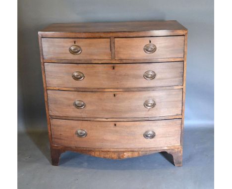 A 19th Century Mahogany Bow-fronted Desk of two short and three long drawers with oval brass handles raised upon bracket feet