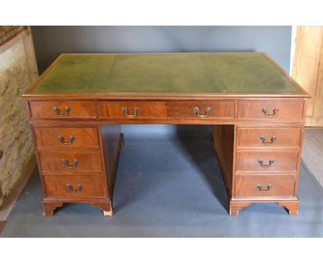 A 20th Century Mahogany Twin Pedestal Desk with tooled leather inset top above nine drawers with brass handles raised upon br