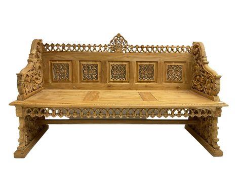 Carved teak garden bench, the cresting rail carved and pierced with foliate design, shaped arms and end supports decorated wi