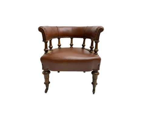 19th century oak tub shaped library chair, the curved upholstered back rail on turned balustrade, on turned front supports wi