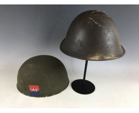 A Second World War British Army motorcyclist's helmet shell bearing insignia, together with one other helmet shell