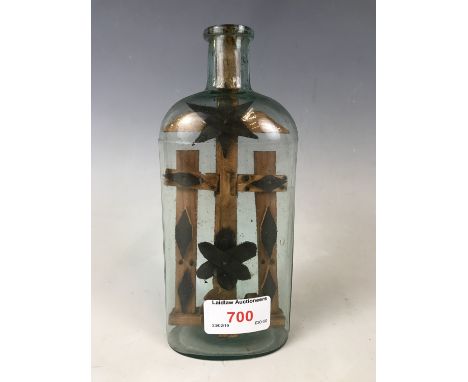 A 19th century miner's / folk art cross in glass bottle