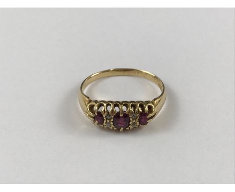 A vintage high-carat gold, ruby and diamond dress ring, having three graded rubies interspersed by pairs of diamond brilliant