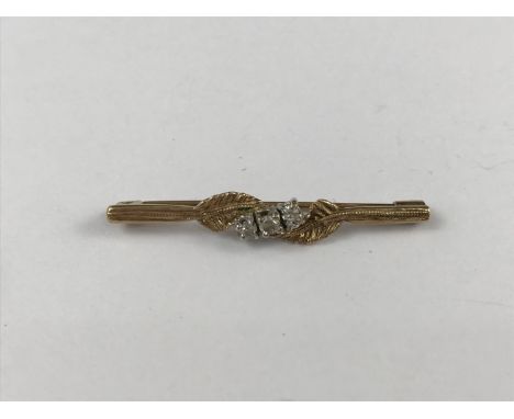 A vintage diamond and 9ct gold bar brooch, having three diamond brilliants held between foliage, 1.9g