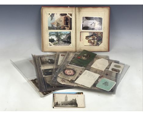 A vintage postcard album together with other postcards