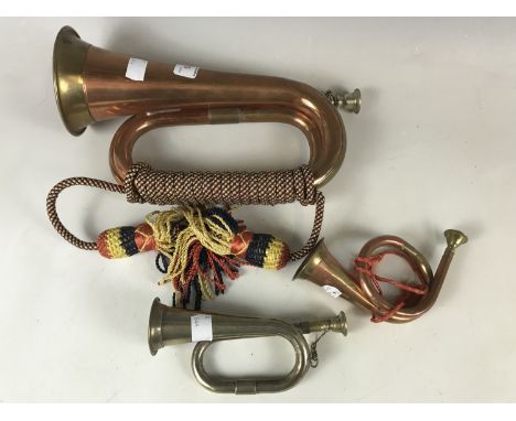 A reproduction copper bugle together with a miniature bugle and horn