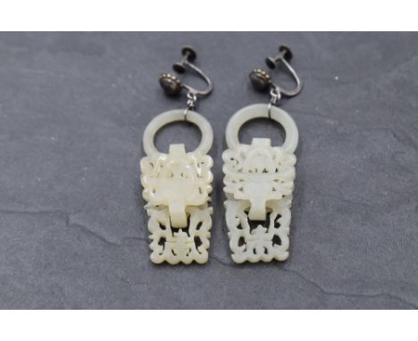 A pair of Chinese carved devil's work  nephrite jade earrings having white metal screw back fittings