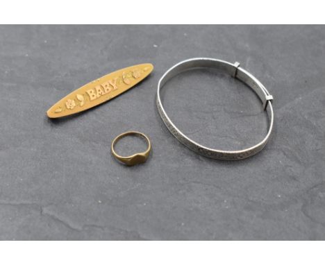 Three pieces of baby's jewellery including silver christening bangle, tiny yellow metal heart shaped signet ring stamped 9ct,