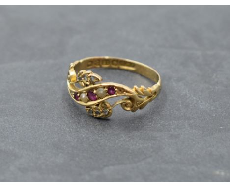 An Edwardian dress ring of shaped band form having inset seed pearls, diamond and ruby chips on an 18ct gold loop, Chester 19