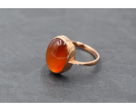 A 9ct rose gold dress ring having an oval orange agate cabochon in a collared mount, size O &amp; approx 2.6g