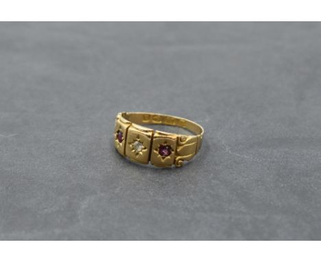 A Victorian 18ct gold band ring having an inset diamond flanked by two rubies with moulded detail to shoulders, size K and ap