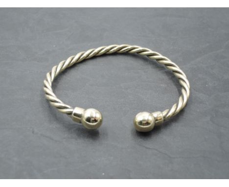 A 9ct gold torque bangle having twist detail and ball knops, approx 30g, 7.5cm diameter, bearing hallmark.
